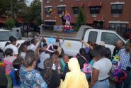 A clown tosses candy to the children 